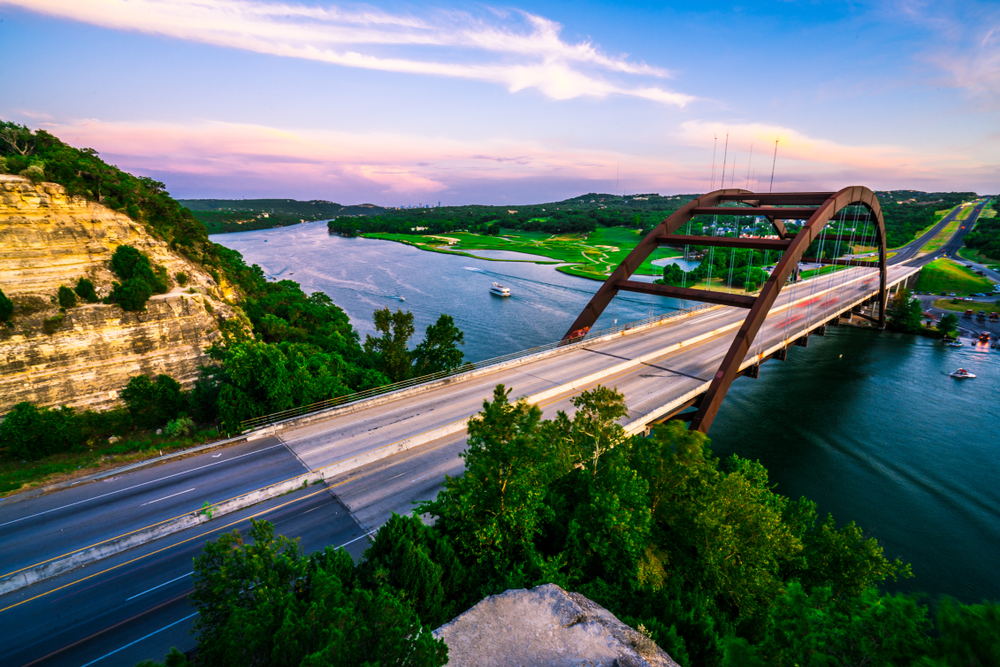 pennybacker bridge with boats at evening